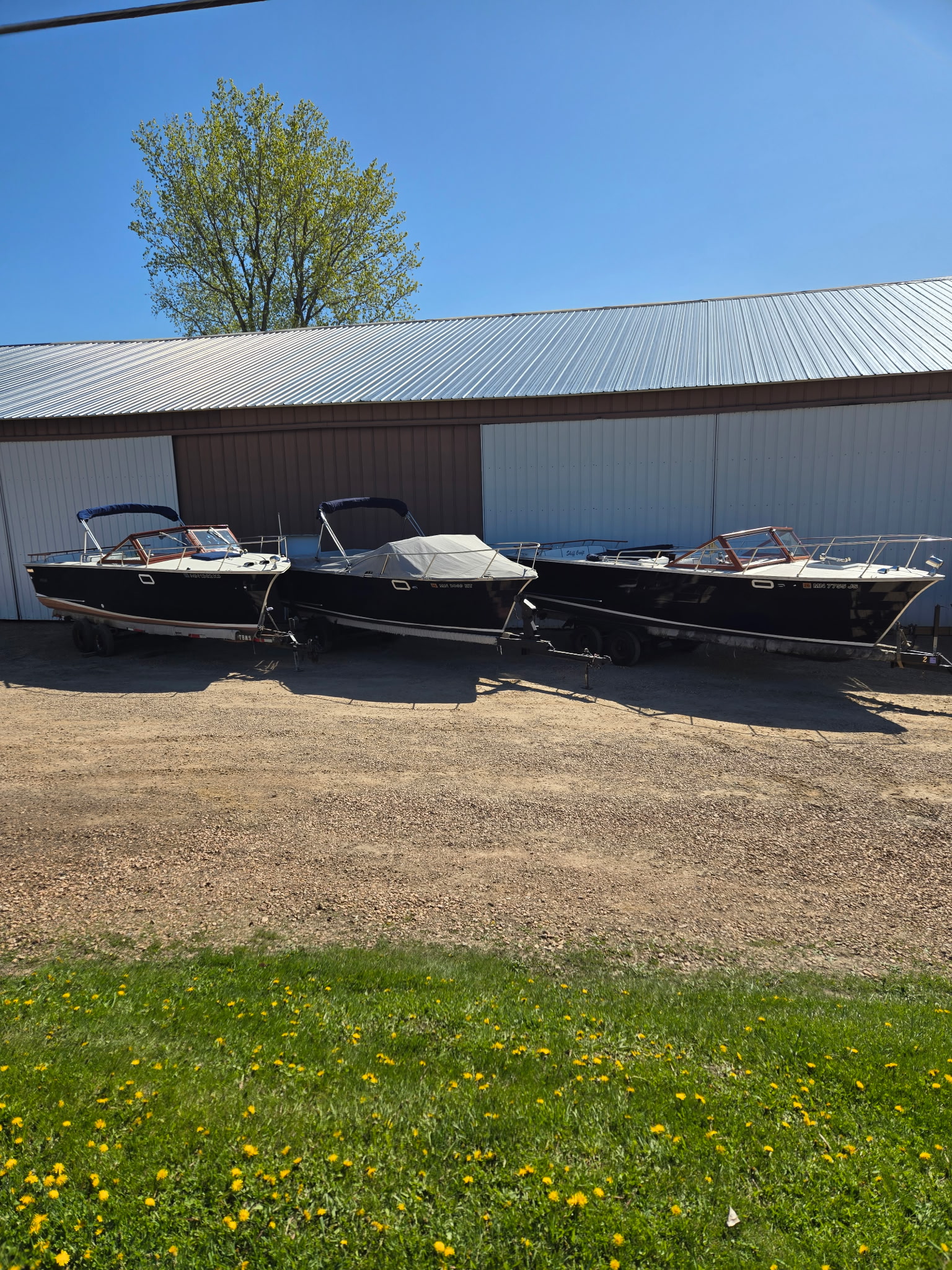 Row of boats on trailers outside Midwest Boat Appeal on a sunny day.