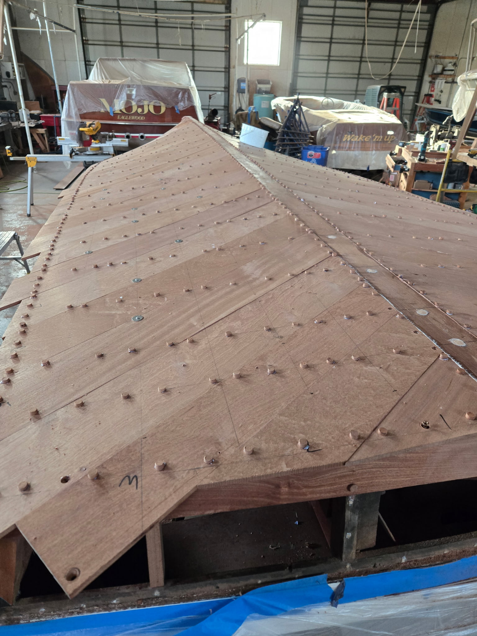 New mahogany deck planks being laid and fastened during restoration.