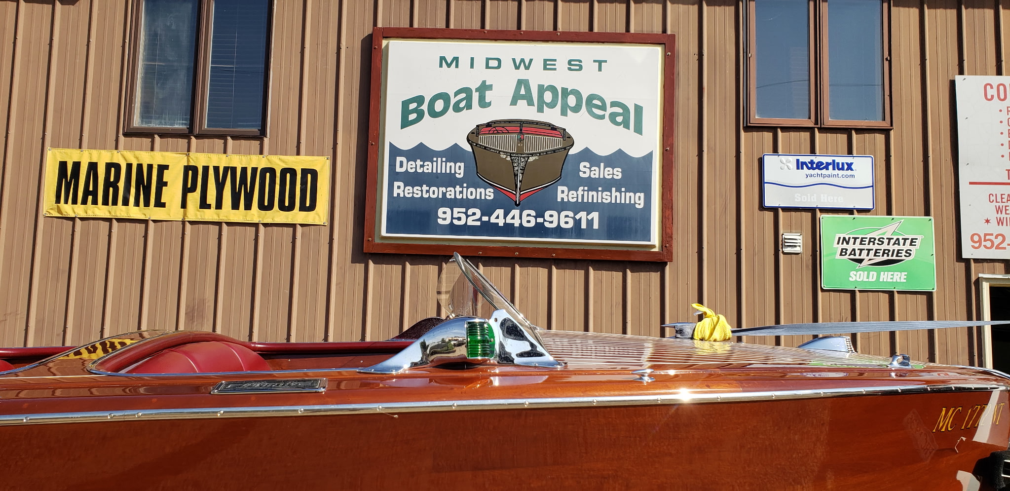 Midwest Boat Appeal shop exterior sign with a classic wooden boat.