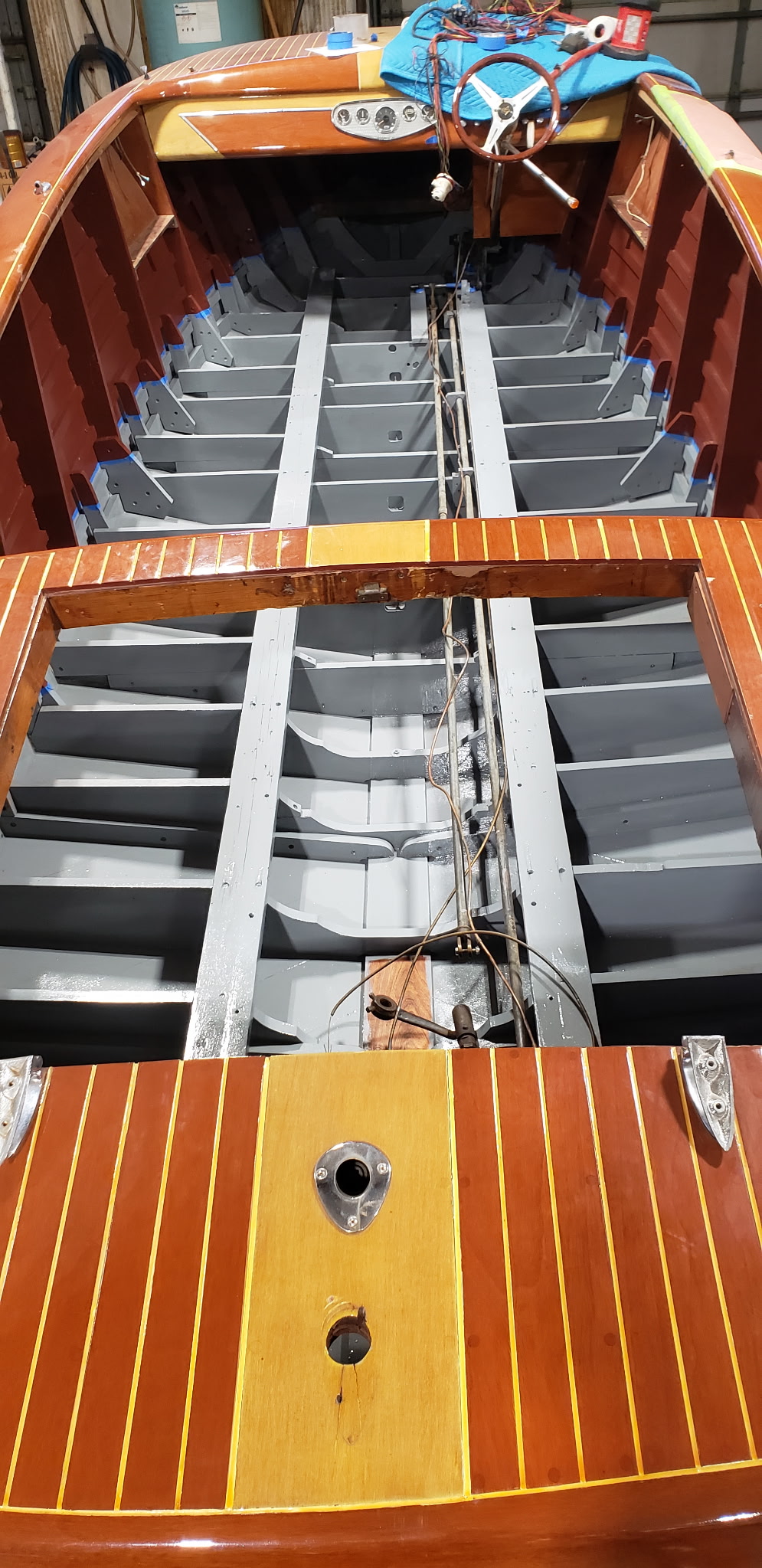 Wood boat interior mid-restoration — new planking and frames in the shop.