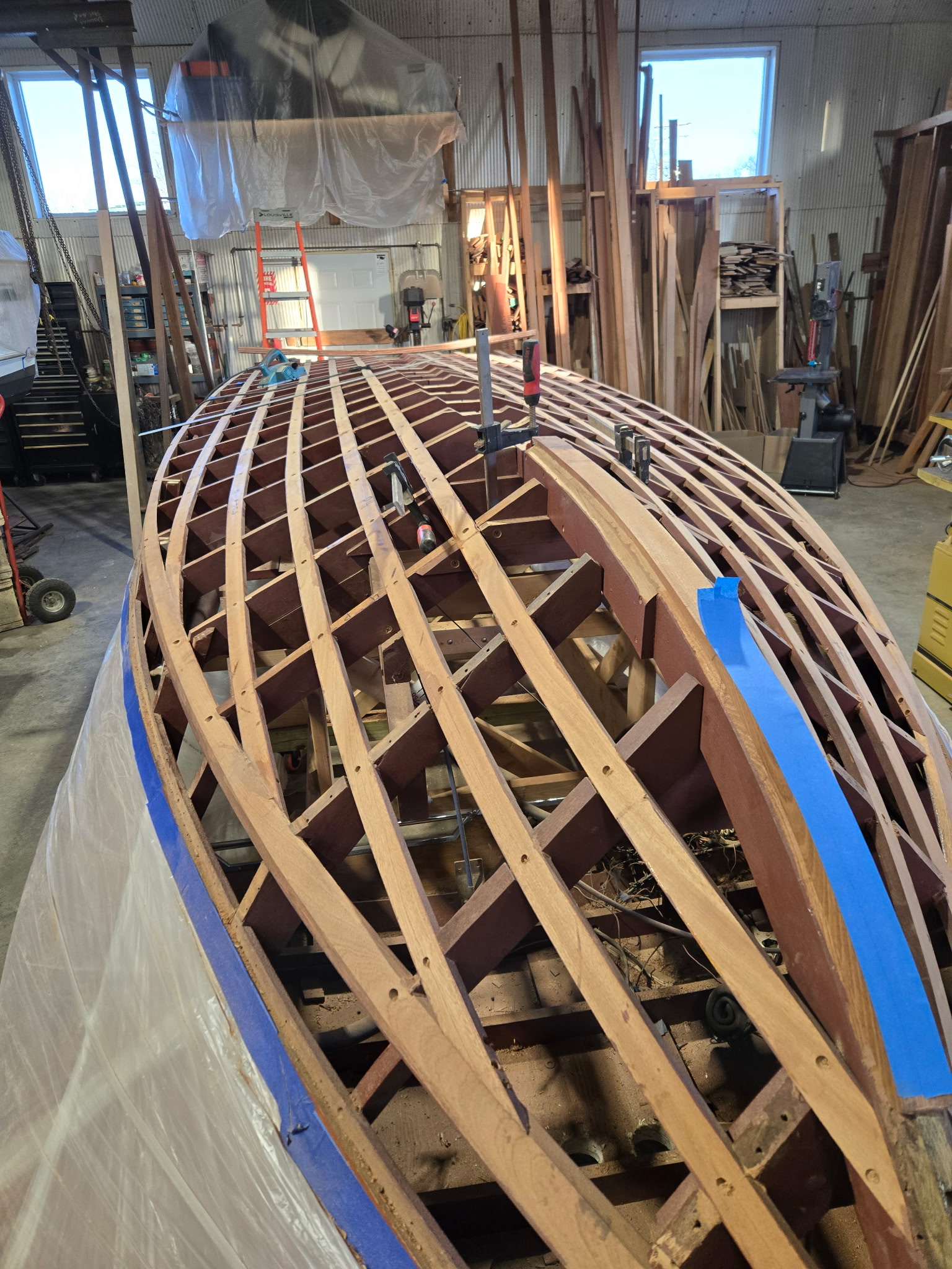 Classic wooden boat stripped to bare frames and ribs in the Midwest Boat Appeal shop.